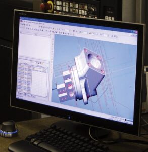 A programming  station sits adjacent to a machine. JD Machine's programming is done by skilled  programmers on  the shop floor. This allows the programmers to have  real time feedback  on problems and  improvements from the machinists and operators.  